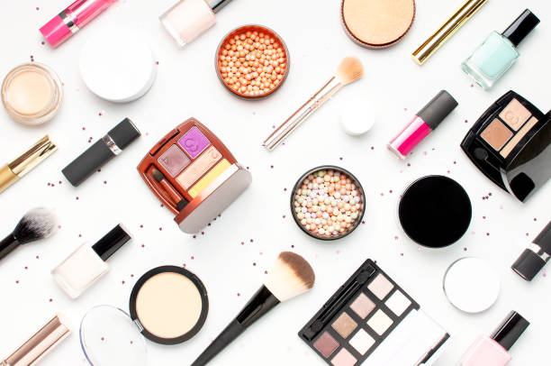 Pattern from Set of decorative cosmetics mascara powder lipstick eyeshadow blush makeup brush, star confetti on light background top view Flat lay. Beauty blogger concept. Fashion background. Makeup