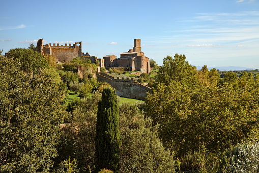 Tuscania, Viterbo, Lazio, Italy: landscape of the countryside with the ruins of the ancient city walls and the medieval Saint Peter church