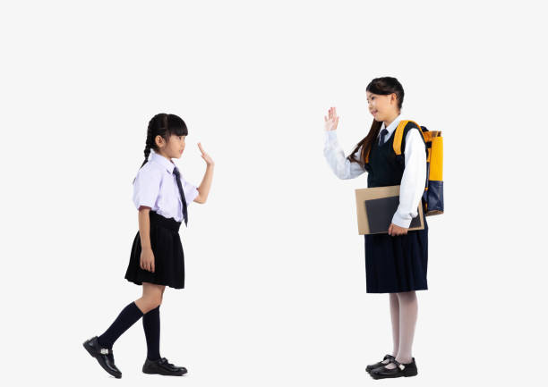 Asian kids in school uniform posing on white background full length.