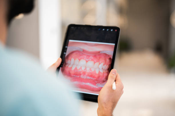 istock Dentist retouching patient's teeth photo on digital tablet 1447630567