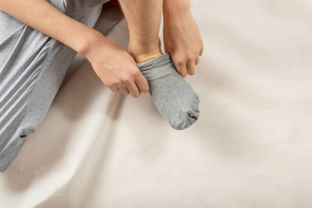 istock Boy Puts on Sock, Man Putting Socks or Take It off 1447633564