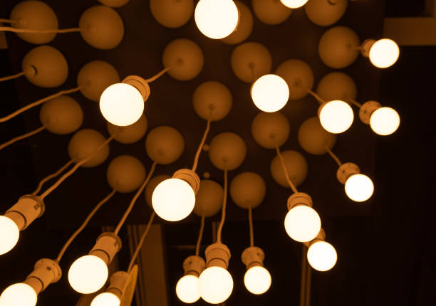 istock Hanging LED Light Bulbs on Blurred Background, Warm Energy Saving Lamp 1447634617