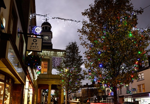 View along the High Street and Fore Street with pretty Christmas decorations lit up at night, Chard, Somerset, UK, Europe.