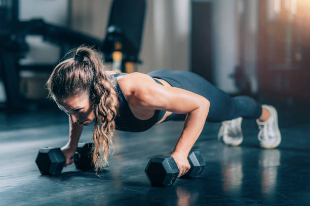istock Woman Doing Push-ups with dumbbells 1447639927