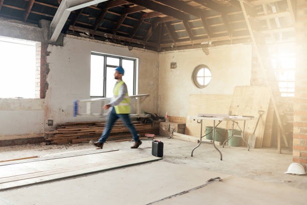 istock Construction, house and contractor walking in a building with maintenance, renovation and work with sunshine. Architecture, home renovation and fast construction worker on a site working as a builder 1447641271