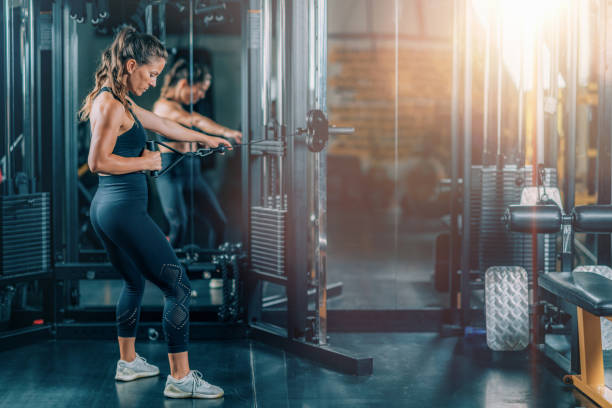 Woman Doing Exercise on a Machine in a Gym stock photo