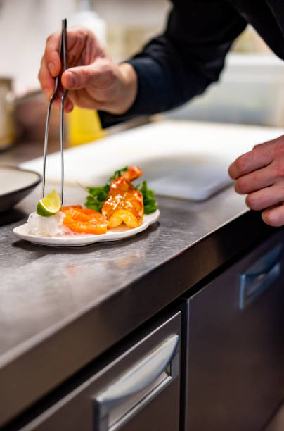 istock chef cooking slice salmon fish and shrimp with salad on kitchen 1447643085