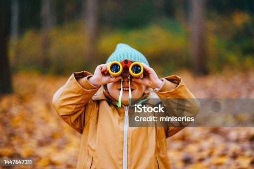 istock Cute Little Girl Holding Small Binoculars in the Woods 1447647311