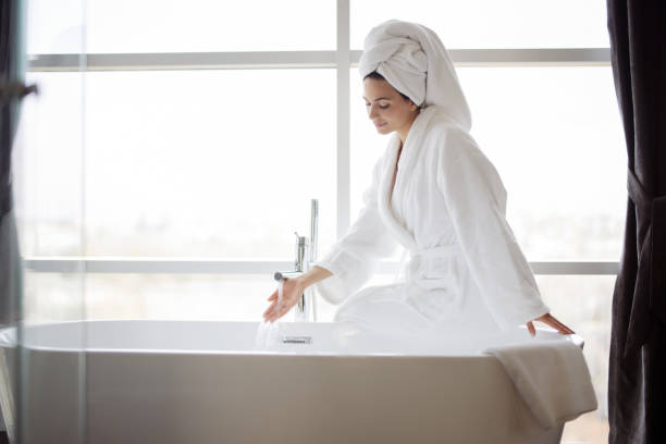 mujer llenando bañera - bathtub women bathroom relaxation fotografías e imágenes de stock