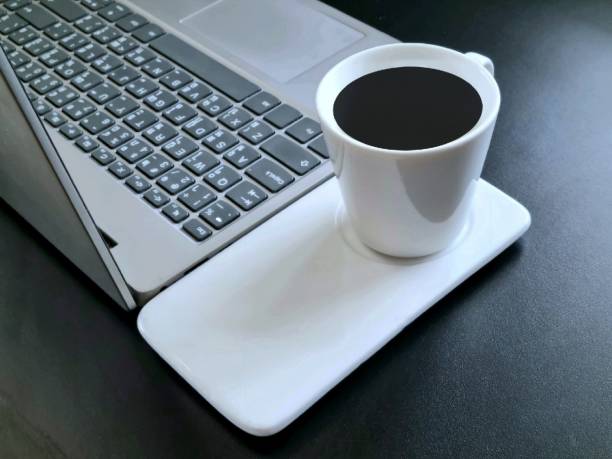 istock Empty laptop on office table with coffee cup and computer mouse, banking finance concept 1447650989