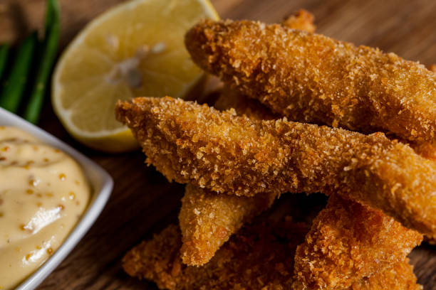 istock Breaded sea fish with sauce, lemon on a wooden table. Horizontal orientation 1447652056