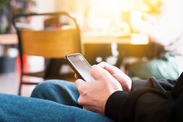 istock Selective focus of Casual young business man hand using mobile smart phone with coffee blurred background 1447652759