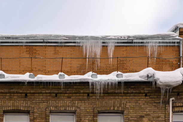 istock Sharp icicles hanging on the edge of the roof. Melting snow forms icicle. 1447652765