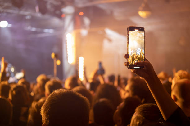 音楽エンターテインメントのパブリックコンサート中にタッチスマートフォンで写真を撮る人 - popular music concert crowd music festival spectator ストックフォトと画像