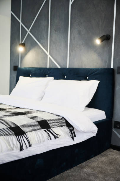 istock Bedroom interior with black bed and soft light hanging against gray wall. 1447657613