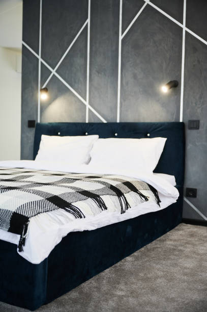 bedroom interior with black bed and soft light hanging against gray wall. - accent wall imagens e fotografias de stock