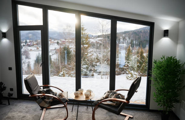 istock Wooden armchairs and small coffee table against panoramic window in winter. 1447657691