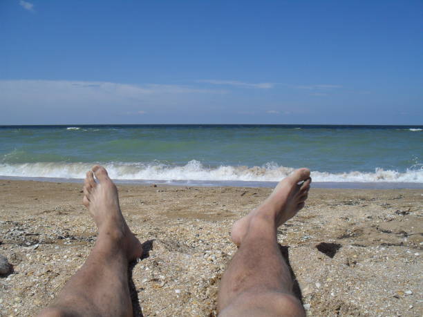 istock man lying on the sand at the beach 1447658039