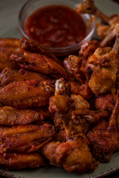 istock Deep-fried chicken legs with sauce on an oval platter. Vertical orientation 1447658953