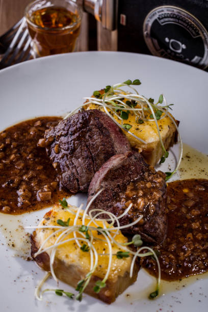 istock Fried beef steak with young shoots, potatoes on a white plate. Vertical orientation 1447660748