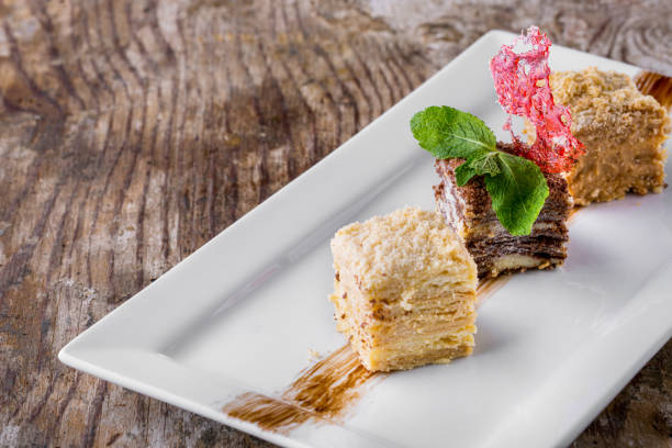 istock Three pieces of napoleon dessert with mint and lace chips on a white plate. Horizontal orientation 1447662342