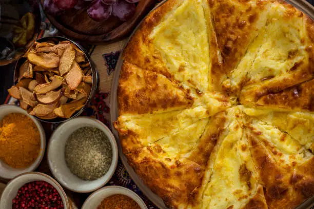 Khachapuri on a plate, grapes, drying apples, spices, a glass of red wine. Horizontal orientation