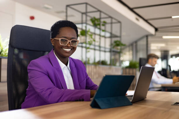 Happy black businesswoman working on laptop in the office. stock photo