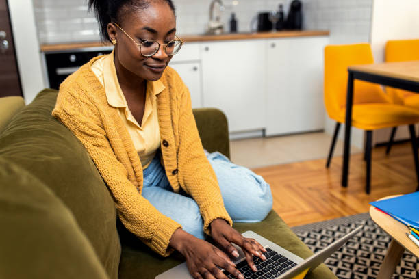 istock Young African American female student studying at home using laptop. 1447665780