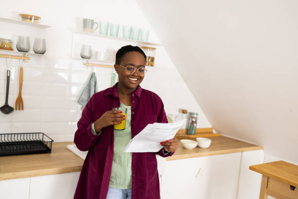 istock Happy African woman doing some paperwork and refreshing at her kitchen 1447667817