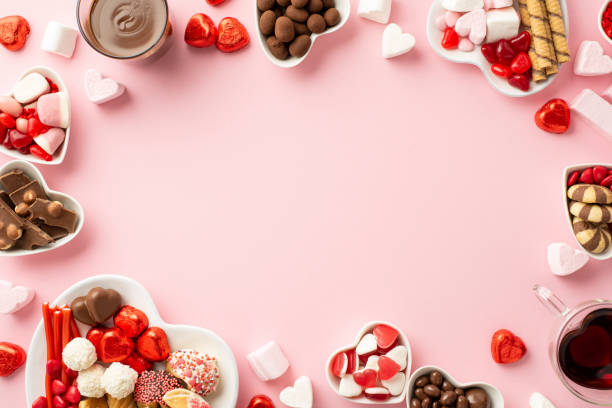발렌타인 데이 개념입니다. 중간에 빈 공간이 있는 격리된 밝은 분홍색 배경에 술을 마시는 과자 사탕과 안경이 있는 하트 모양의 접시의 상위 뷰 사진 - valentine candy 뉴스 사진 이미지