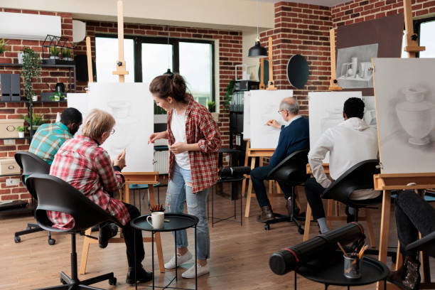 istock Young teacher helping senior woman to develop illustration technique 1447672990