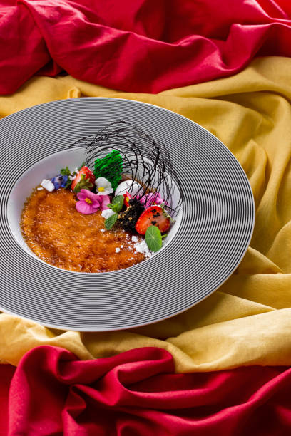istock Dessert with chocolate threads, strawberries, mint, and flower petals on a round plate. Vertical orientation 1447673303