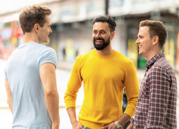 A group of friends stopping for a chat on the pavement during a trip to London.