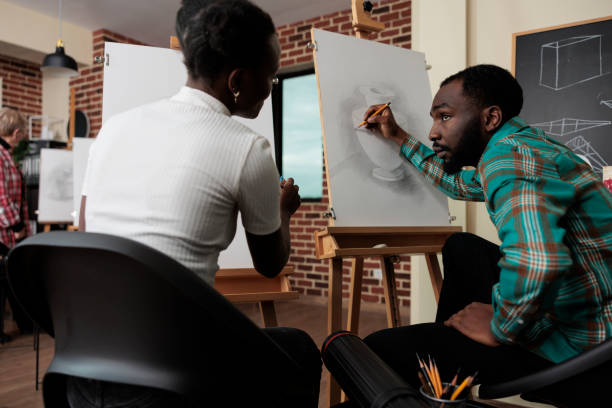 istock Painter collegues sitting in front on painting canvas drawing vase model 1447673737