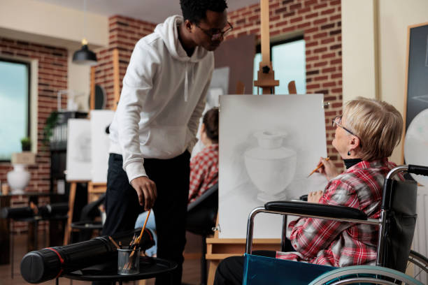 istock Art student in wheelchair drawing at easel 1447673910