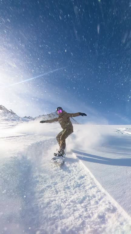 Extreme freeride snowboarder riding fresh powder snow and doing powder turns off piste