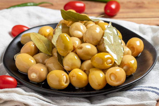 Green olives with cheese filling on a wooden background. Gourmet delicacies. close up stock photo