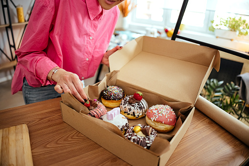 Woman packs donuts into a box