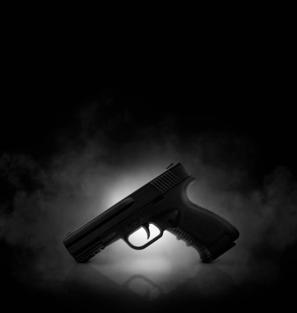 Chrome gun on black background with smoke Chrome gun on black background with smoke gun mafia handgun bullet stock pictures, royalty-free photos & images