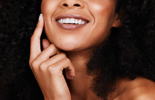 Black woman, smile and touch face with natural beauty, pride and confident with curly hair. Cosmetics, African American female and young lady with skincare, happy and organic facial with smooth skin