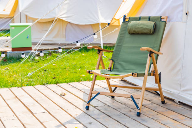ein campingstuhl neben dem zelt - campingstuhl stock-fotos und bilder