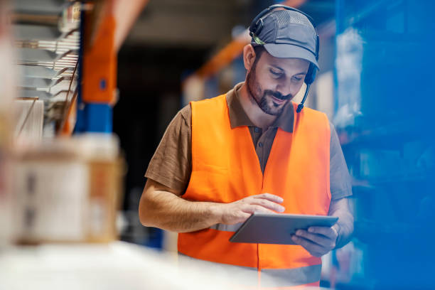 un lavoratore espresso postale che controlla la spedizione su tablet. - warehouse freight transportation checklist industry foto e immagini stock