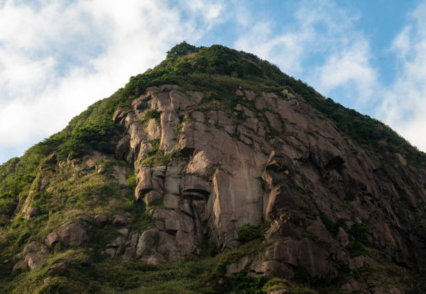 istock Look up to the mountain, gorgeous rocks make a great cliff, grass growing between the rocks, in Jinguashi, New Taipei City, Taiwan. 1447687677
