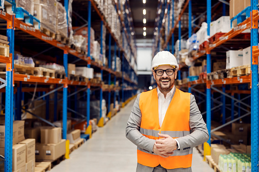Portrait of a businessman in warehouse smiling at the camera.
