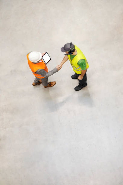 top view of a storage worker shaking hands with new director. - manual worker handshake industry warehouse imagens e fotografias de stock