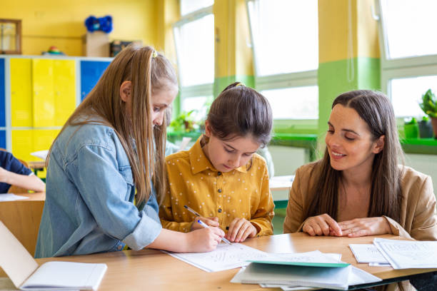 istock Schoolgirls learning together in the classroom 1447689393