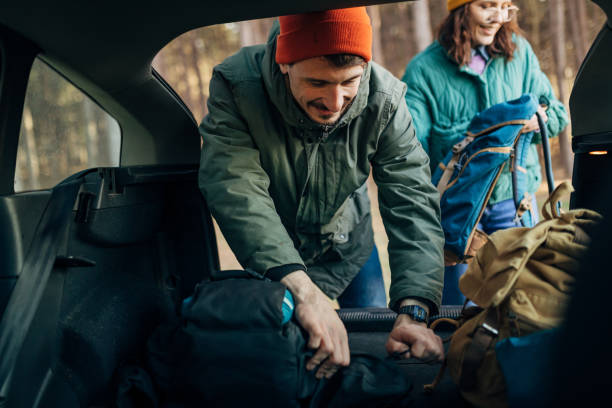 istock Couple in love taking camping backpacks from car trunk 1447690738