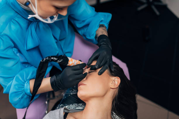 istock A tattoo artist is tattooing a woman's eyebrows using a tattoo machine 1447692057