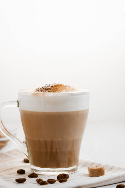 istock Latte coffee poured in layers with froth and a crispy chocolate top on a light kitchen table. Vertical image with copy space 1447694835