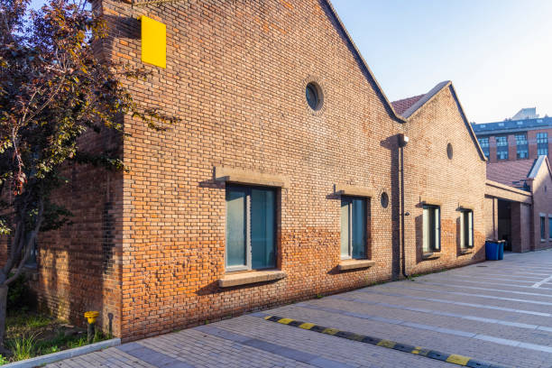 old brick industrial building with green windows.